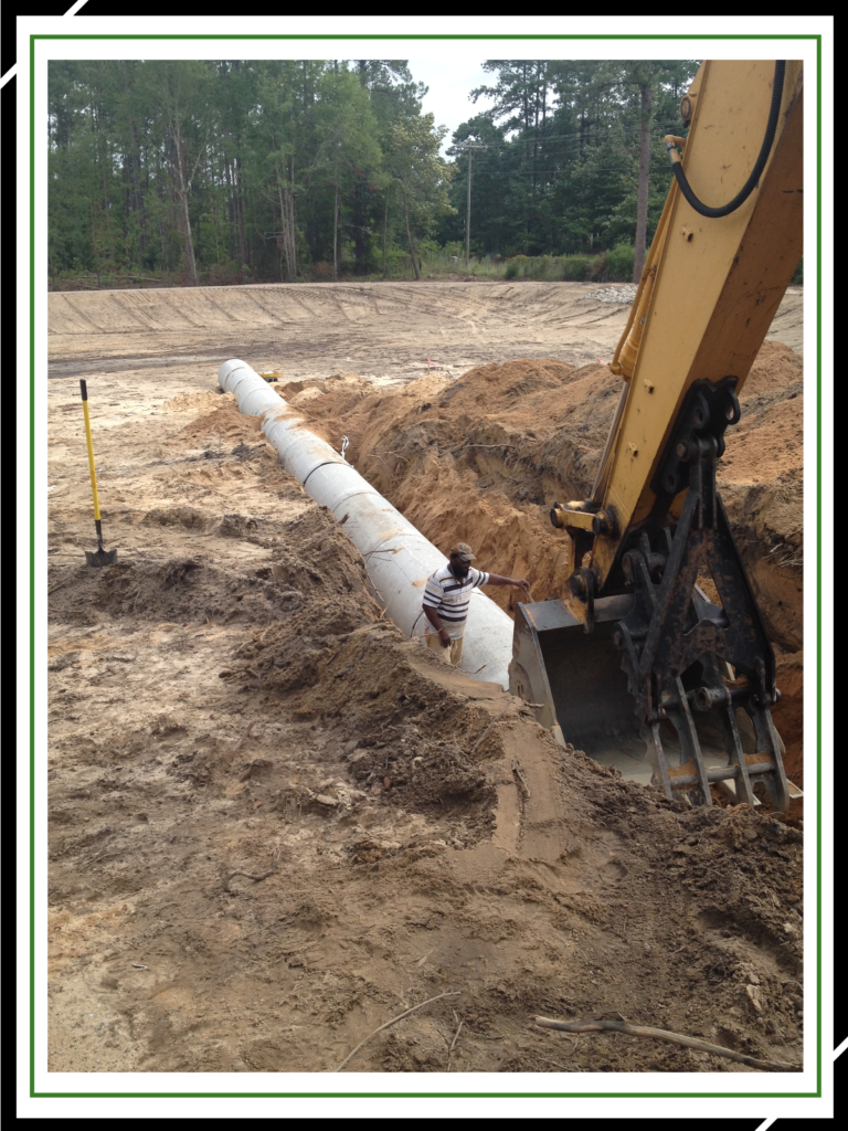 A Person Installing Water Pipe With Help Of Backhoe